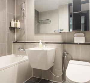 a bathroom with a white sink and a toilet at Vourne Osiria in Busan +22 photos