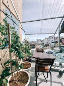 Un balcón con mesa y sillas y plantas. en Petite Dalat - Boutique Hotel, en Da Lat 102 fotos más
