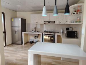 a kitchen with a white table and a refrigerator at Dulce Hogar 01 in Loja