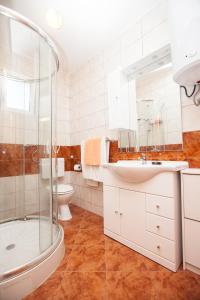 a bathroom with a shower and a sink and a toilet at Villa Stana in Vinišće