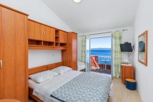 a bedroom with a bed and a view of the ocean at Apartments and rooms by the sea Podgora, Makarska - 2616 in Podgora