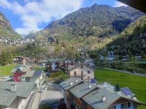 a village with houses and mountains in the background at La mansarda in Valmalenco in Chiesa in Valmalenco