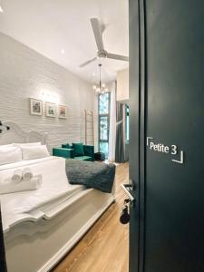 1 dormitorio con 1 cama blanca y 1 sofá verde en Petite Dalat - Boutique Hotel, en Da Lat