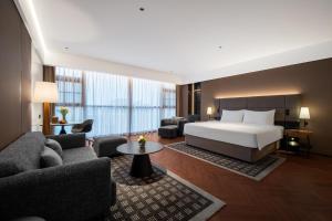 a hotel room with a bed and a living room at IntercityHotel Shanghai Pujiang Center in Shanghai +92 photos