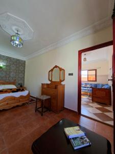 Un dormitorio con una cama, una mesa y un espejo. en Casa Mogador, en Essaouira