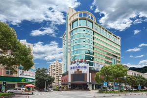 a tall building on a city street at Quanzhou West Street Wanda Plaza Urbain Hotel in Quanzhou