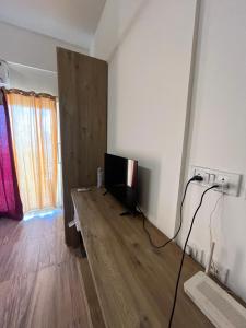 sala de estar con TV y suelo de madera en Studiovibe, en Greater Noida