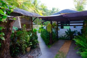 a garden with a large umbrella and some plants at Skott's Comfy Lodge in Bantayan Island