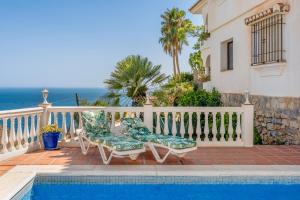 einen Balkon mit 2 Stühlen und einem Pool in der Unterkunft Villa Andaluza in Almuñécar