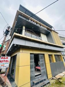 un edificio amarillo y negro con un cartel en él en Raja Ki Hotel, en Orchha