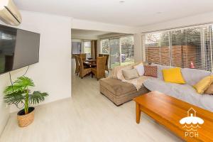 a living room with a couch and a table at Family Tidez in Sandy Point +5 photos