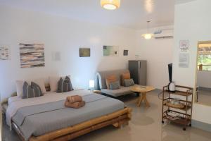 a bedroom with a large bed and a couch at Skott's Comfy Lodge in Bantayan Island