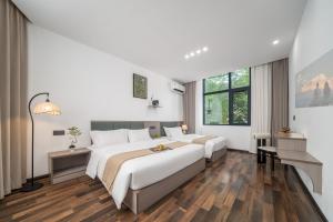 Una habitación de hotel con dos camas y una ventana. en Wangxian Mountain Retreat B&B-Wangxian Valley Scenic Area, en Qiaotou