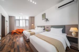 una habitación de hotel con dos camas y una mesa en Wangxian Mountain Retreat B&B-Wangxian Valley Scenic Area, en Qiaotou