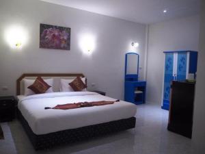 a bedroom with a large bed and a mirror at At night Airport Resort in Patong Beach