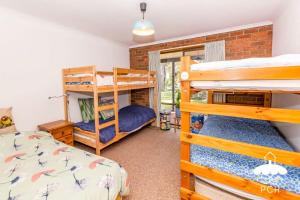 Un dormitorio con dos literas y una cama. en Wattle Haven Stay 3 Pay 2 Sept to Oct, en Sandy Point 6 fotos más