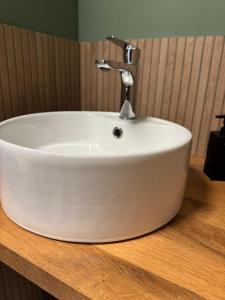 a white sink on a wooden counter in a bathroom at My Star Apartment in Maribor