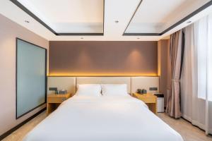 a bedroom with a large bed and a large window at Zhuhai Jinjunyao Hotel in Zhuhai