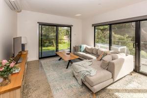a living room with two couches and a table at 1 Anderson Avenue Sandy Point in Sandy Point