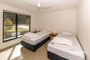 two beds in a room with a window at 1 Anderson Avenue Sandy Point in Sandy Point
