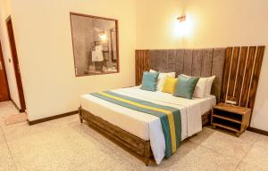 a bedroom with a large bed with colorful pillows at Nethra Beach in Hikkaduwa