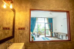 a bathroom with a mirror and a large window at Nethra Beach in Hikkaduwa +43 photos