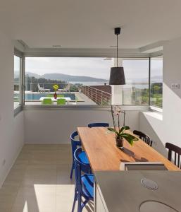 Cabana de BergantiñosにあるVilla en Pedracuca Novaのダイニングルーム(木製テーブル、青い椅子付)