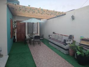 a patio with a table and an umbrella at Loft Estudio El Faro - Zona Estero Beach in Ensenada