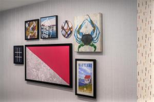 a group of framed pictures on a wall at Home2 Suites by Hilton Lexington Park Patuxent River NAS, MD in Lexington Park +29 photos