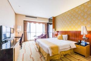 pokój hotelowy z łóżkiem i telewizorem w obiekcie Foshan Nanhai Huifeng Holiday Hotel w mieście Foshan