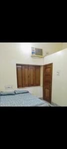 una camera da letto con un letto e un armadio in legno di Gopal Geeta Niwas a Bikaner