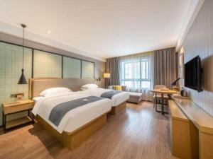 a bedroom with a large bed and a television at Echarm Hotel Nanchang Hongcheng Wangfujing in Taohua +134 photos