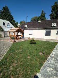 a backyard with a picnic table and a building at BB64 Apartmanház in Békéscsaba