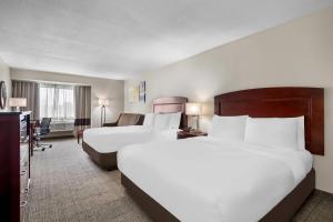 a hotel room with two beds and a desk at Comfort Inn & Suites North East in North East +28 photos