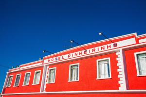 un edificio rojo con una entrada de hotel en la parte superior en Hotel Pinheirinho, en Curitiba