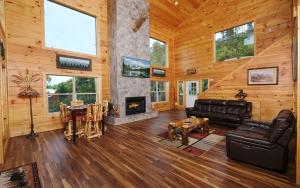 a living room with a fireplace in a log cabin at Eagles View 2.0 - Gorgeous Mountain Views, Hot Tub, Pool Table, + Games! in Gatlinburg