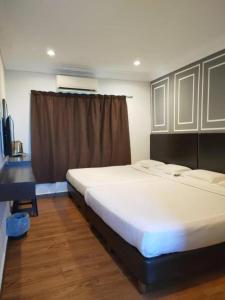 a bedroom with two beds and a window at Sea Lion Hotel Pulau Ketam in Bagan Teochew