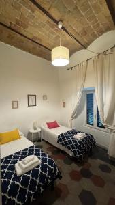a bedroom with two beds and a window at La maison b8 in Rome