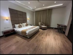 a hotel room with a large bed and a desk at Hotel Golden Palm in Gurdāspur