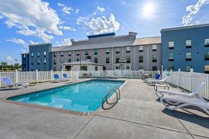 a pool in front of a hotel with lounge chairs at Comfort Inn & Suites River City Decatur in Decatur