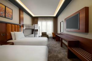 a hotel room with two beds and a flat screen tv at TRYP by Wyndham Istanbul Maltepe in Istanbul +55 photos