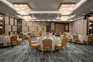a conference room with tables and chairs and chandeliers at TRYP by Wyndham Istanbul Maltepe in Istanbul