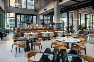 a restaurant with tables and chairs and windows at Canopy By Hilton Nashville Downtown The Gulch in Nashville