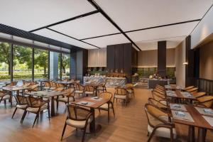 苏州苏州工业园区独墅湖戴斯温德姆酒店的有木桌椅和窗户的餐厅