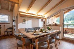 a dining room with a large wooden table and chairs at Marias Alpen Apartment by Alpine Host Helpers in Brixen im Thale