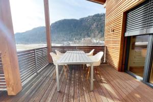 a wooden deck with a table and chairs on a balcony at Ski & Golf Auszeit Apartment by Alpine Host Helpers in Kitzbühel