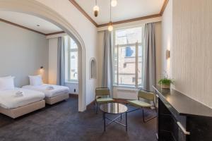 una stanza d'albergo con un letto, un tavolo e delle sedie di Hotel Lucca a Bruges