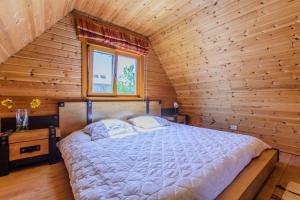 ein Schlafzimmer mit einem Bett in einer Holzhütte in der Unterkunft Bedugnės pirtelė - Cosy Sauna House in Vilnius