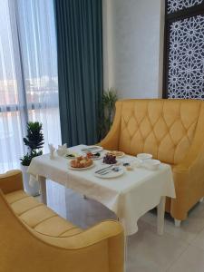a table with food on it with two chairs at Saroy Gardens Hotel in Fergana