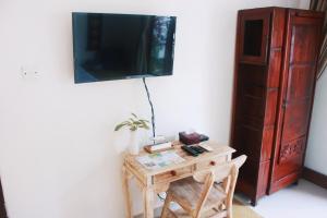 ein Raum mit einem Tisch und einem Fernseher an der Wand in der Unterkunft ThanTha Ubud Villa in Ubud + 154 Fotos